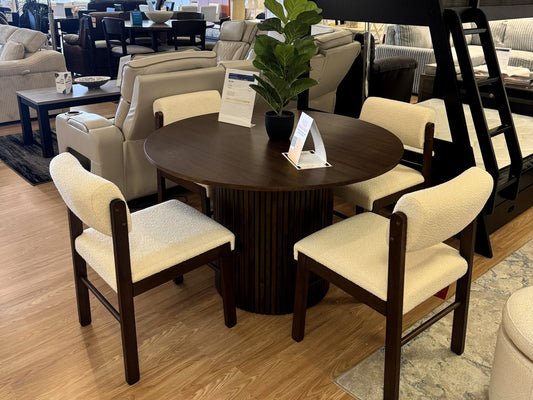 Round dining table with cream chairs at Palacio Furniture