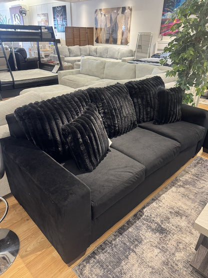 Black velvet sofa with faux-fur back pillows