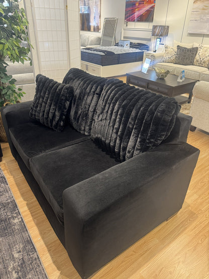 Black velvet loveseat with faux-fur back pillows